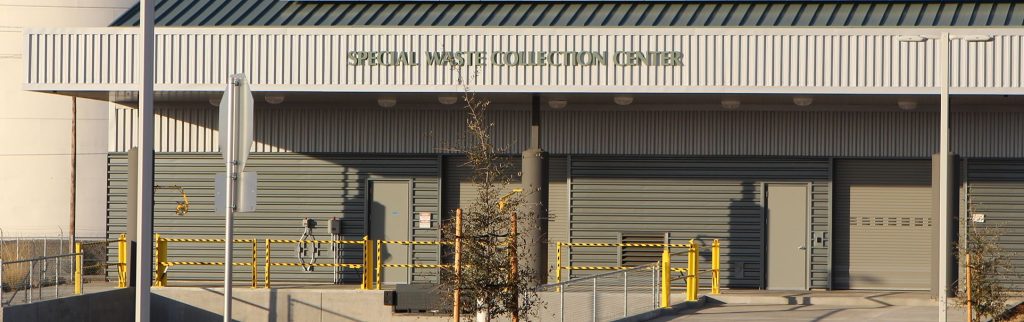 Special Waste Collection Center building with closed gray doors and yellow safety railings.