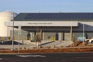 Modern building with solar panels labeled Special Waste Collection Center under a clear sky.