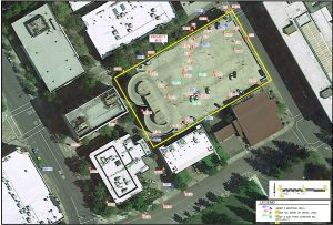 Aerial view of a building and parking lot outlined in yellow, labeled Project Site in an urban area.